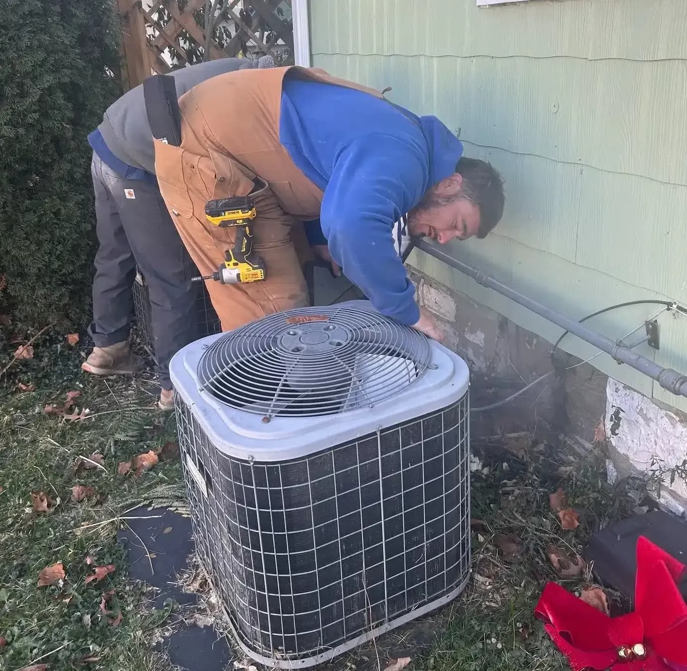 Technician working on AC unit outside of residential home in Lexington, KY.