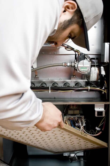Technician replacing HVAC filter