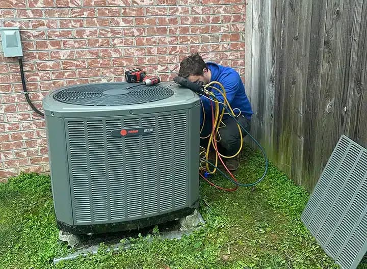 Synergy technician repairing air conditioner outside of residential home in Lexington, KY.