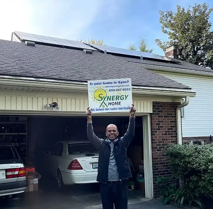 Synergy solar customer smiling in front of new solar panels in Lexington, KY.