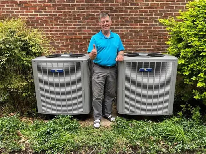 Customer in front of 2 new air conditioners in Lexington, KY.