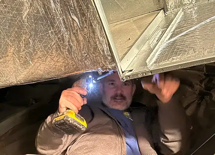 Technician working on HVAC duct in Lexington, KY.