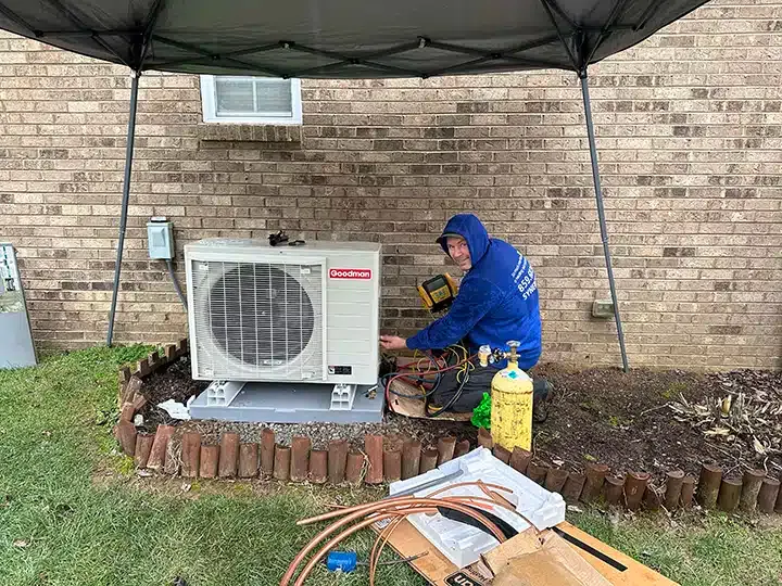 Synergy technician installing heat pump outside of residential home in Lexington, KY.