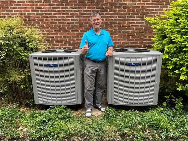 Customer in front of 2 new air conditioners in Lexington, KY.