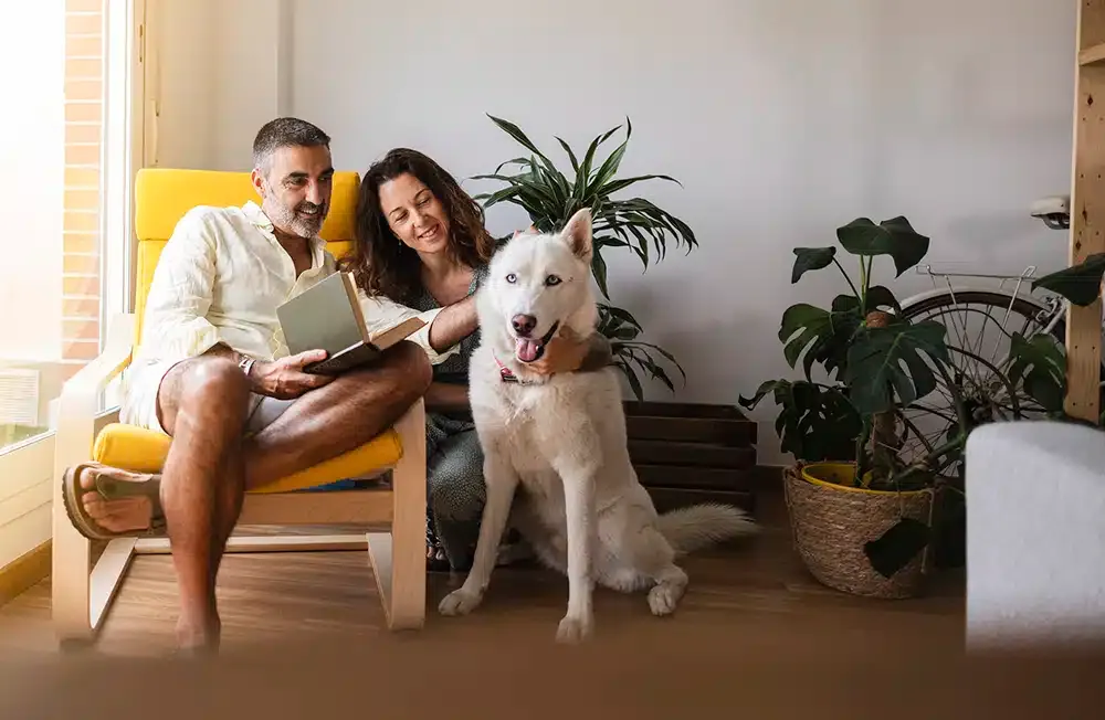 Family smiling with dog reading book in residential home in Lexington KY.