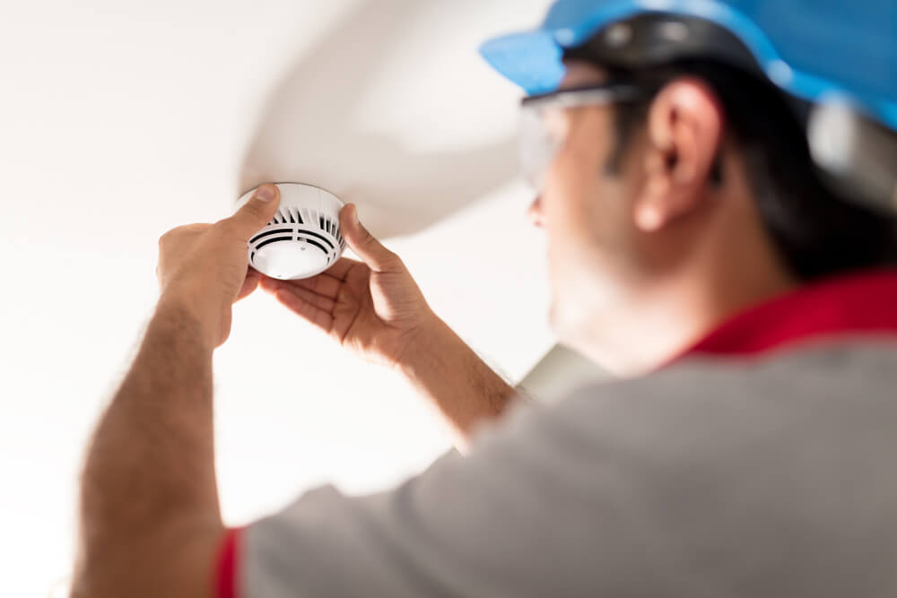 A professional installing a smoke detector