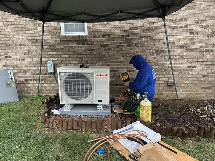 Synergy technician installing heat pump outside of residential home in Lexington, KY.
