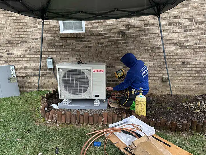 Synergy technician installing heat pump outside of residential home in Lexington, KY.