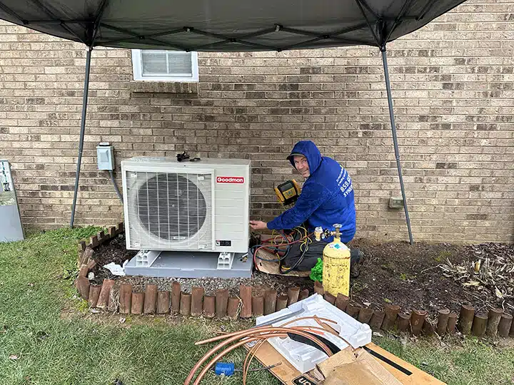 Synergy technician installing heat pump outside of residential home in Lexington, KY.