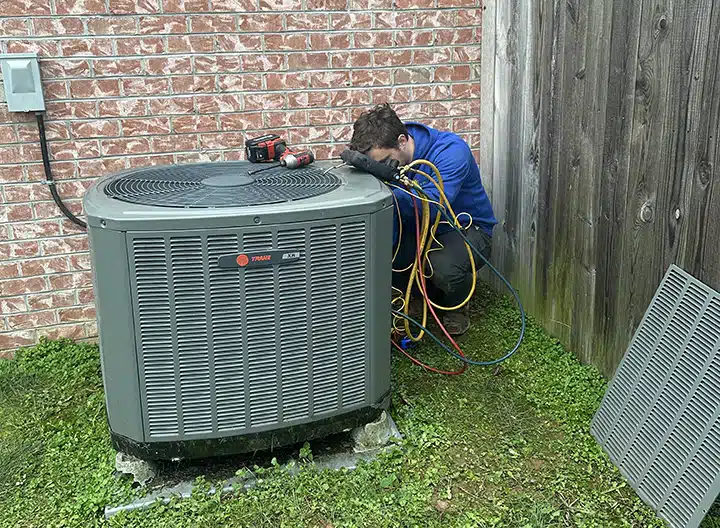 Synergy technician repairing air conditioner outside of residential home in Lexington, KY.